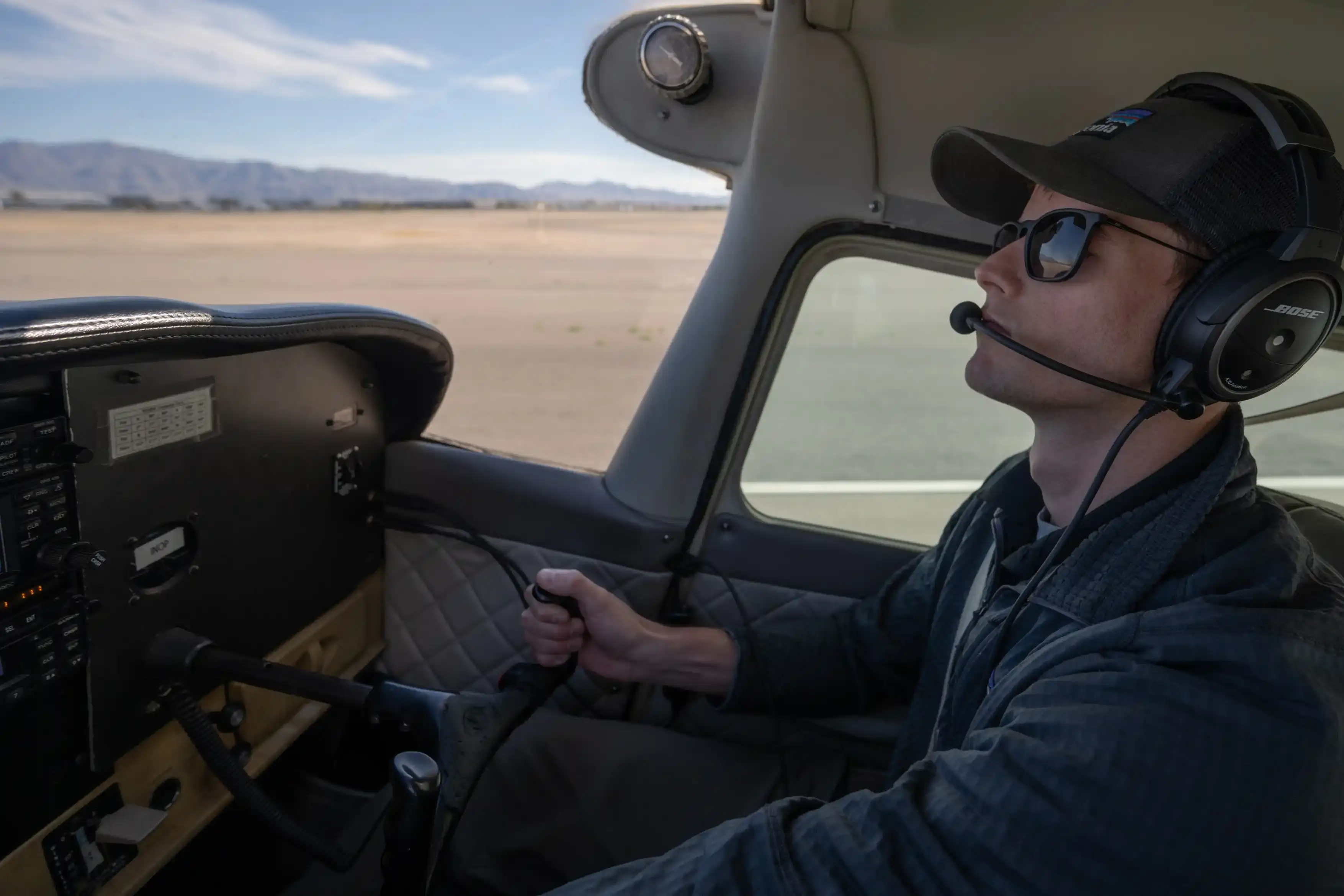 Pilot wearing a headset at the controls of a Vegas Aviation airplane