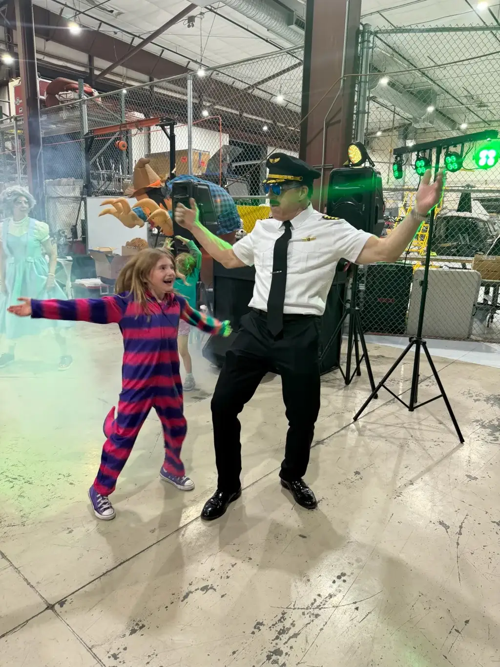 Guest in a pilot costume dancing with a child at Vegas Aviation