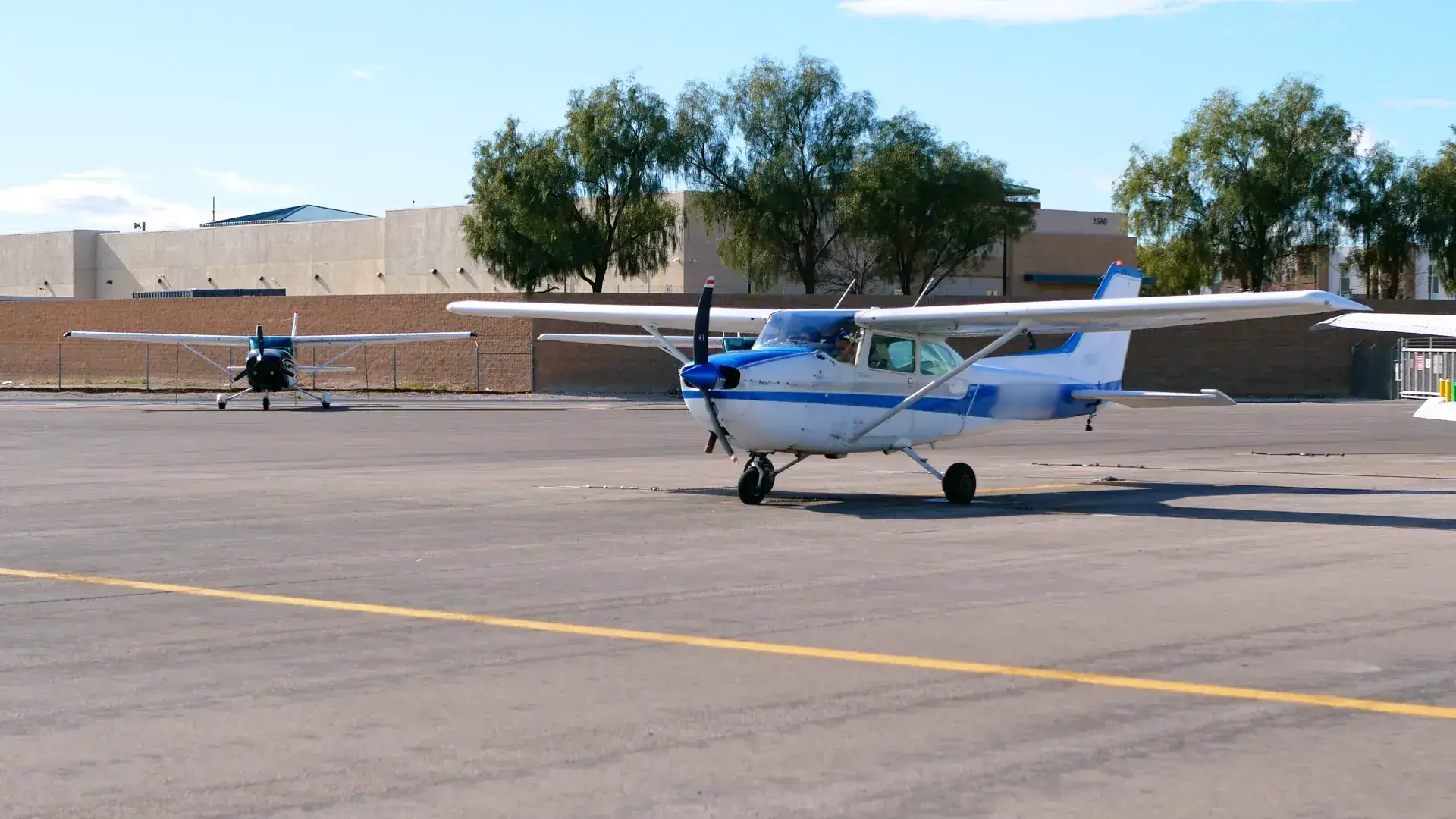 Two training aircraft parked together on the ramp