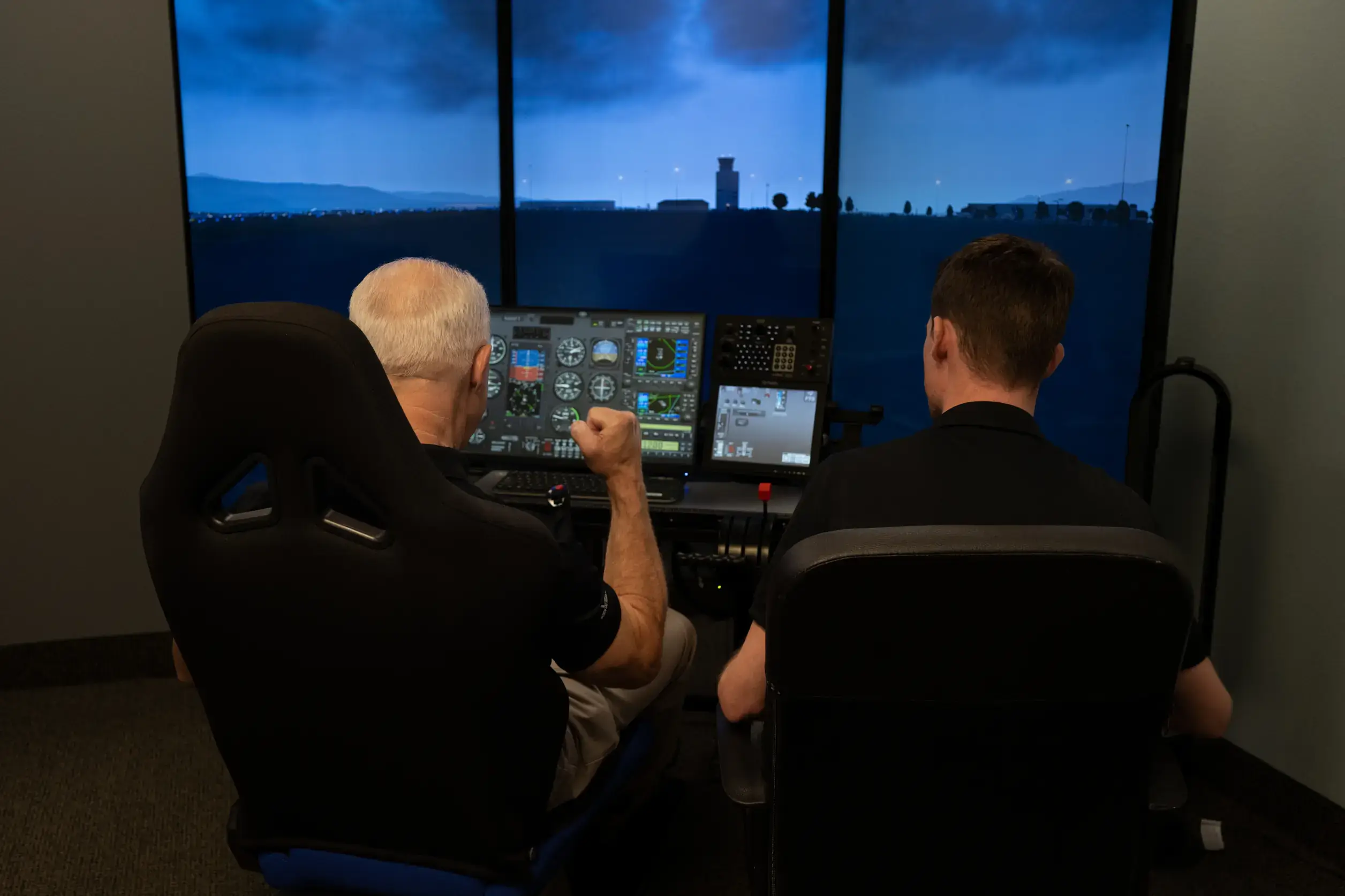 Two people using the Vegas Aviation flight simulator during a training session