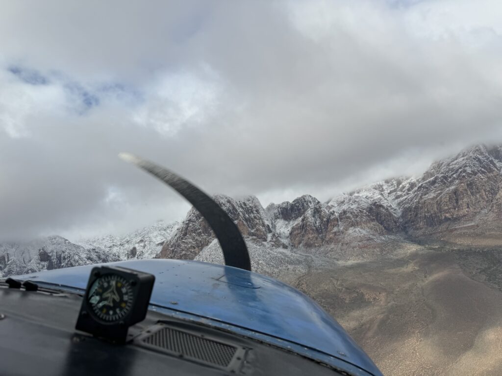 View of the front of an aircraft flying in the direction of a mountain range
