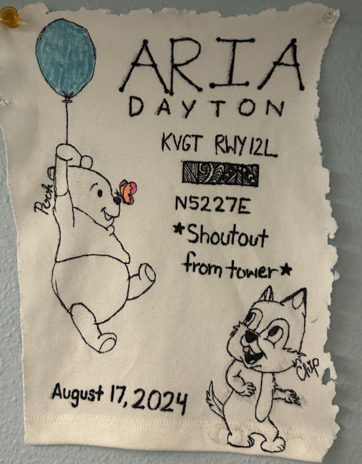 Aria Dayton's cut shirt with writing representing their first solo flight