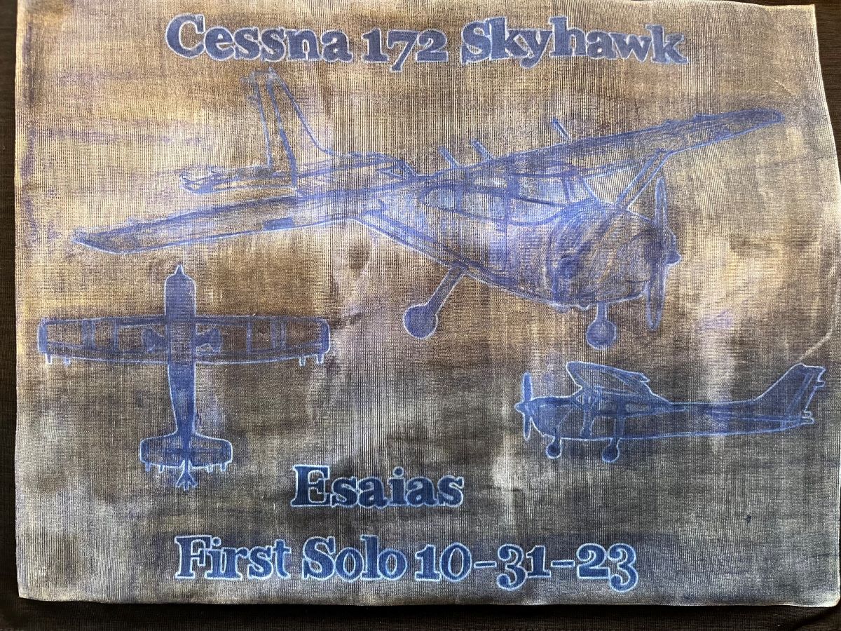 Esaias' cut shirt with writing representing their first solo flight