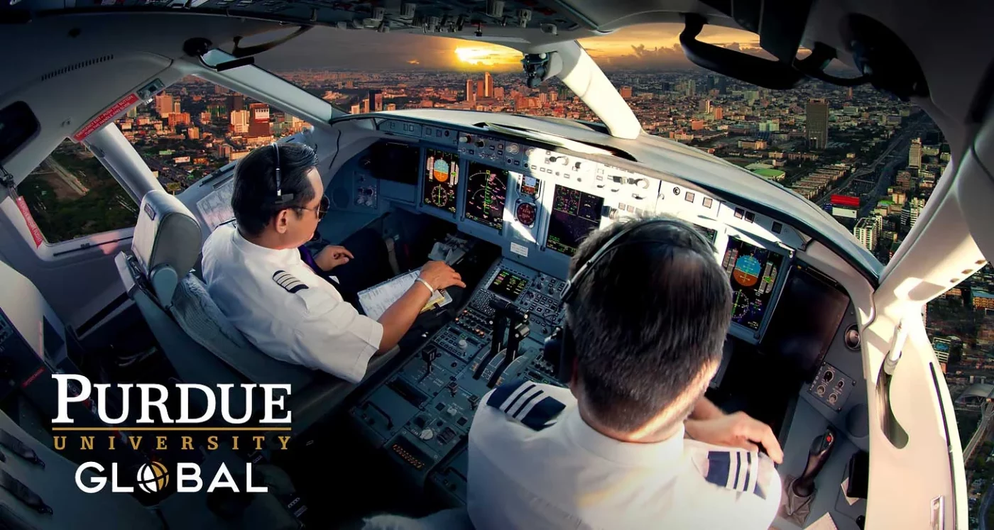 Purdue University Global aviation students in a commercial jet cockpit at sunset
